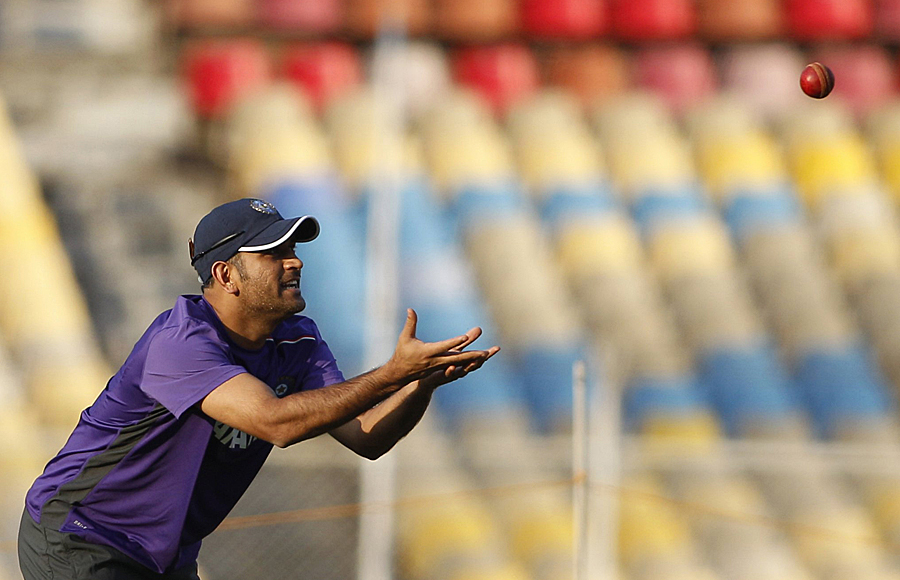 Dhoni prepares to catch during a practice session 