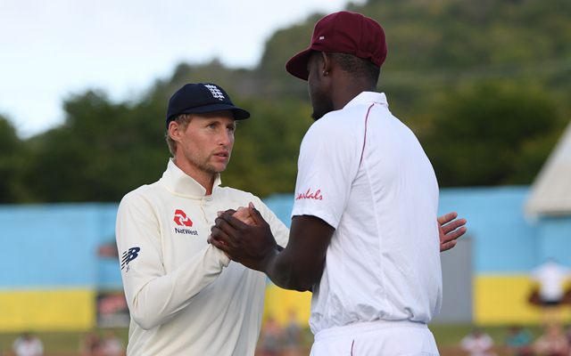 Joe Root talks with Jason Holder